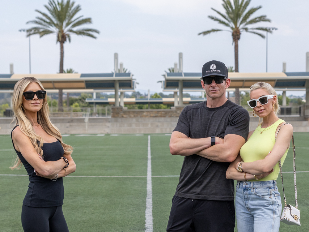 Christina Haack, Tarek El Moussa and Heather El Moussa on the soccer field looking away from camera, as seen on The Flip Off, Season 1.